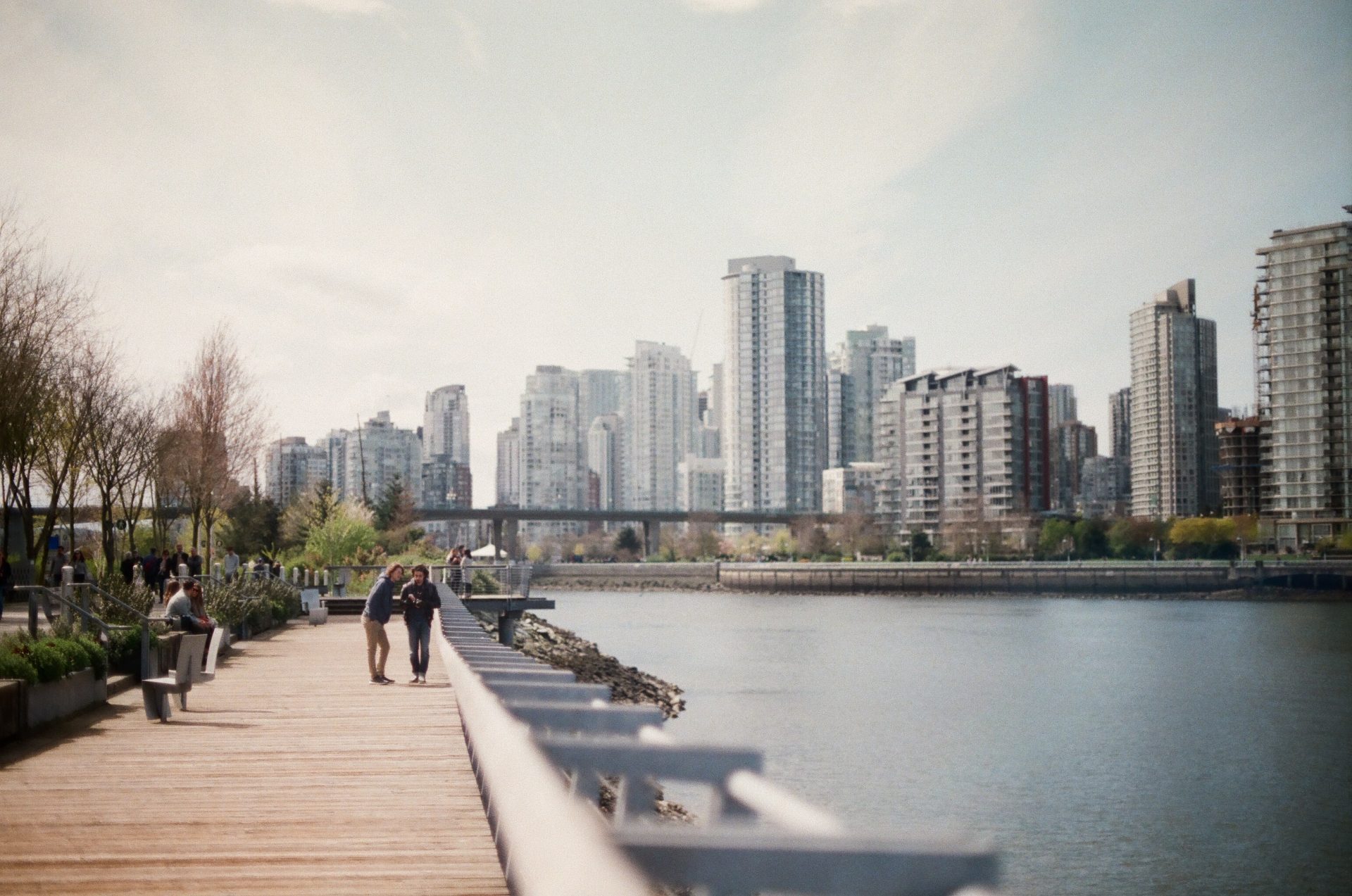 visti per il canada: due persone sul lungomare e in lontananza lo skyline di vancouver