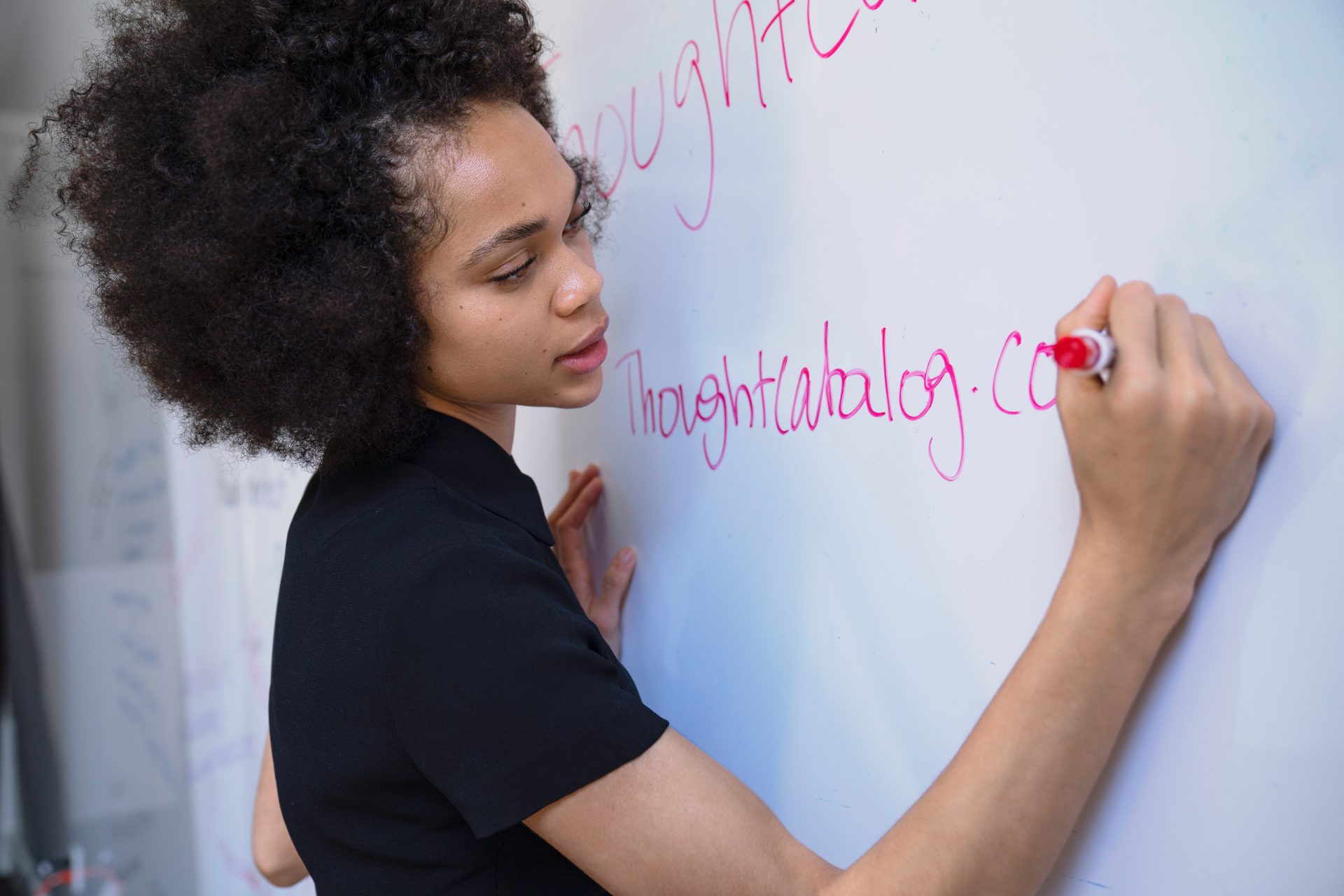 studentessa scrive su una lavagna bianca